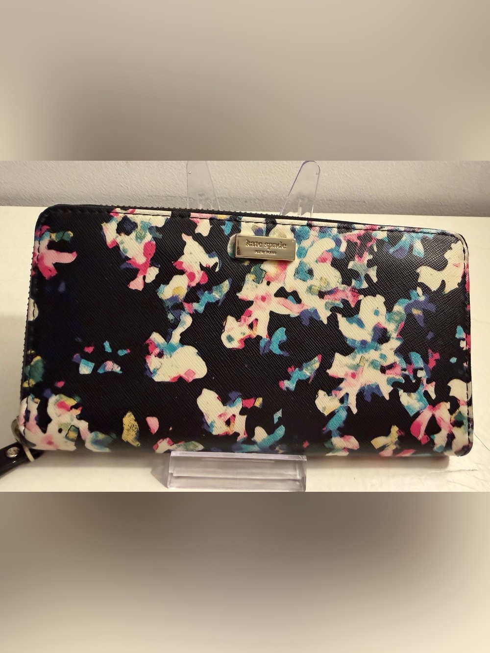 Kate Spade zip-around wallet with a watercolor floral print over a black base.